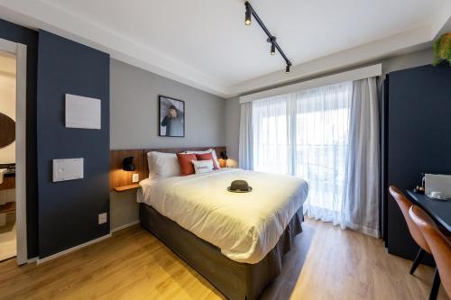 a bedroom with a large bed and a large window at House of Charlie Paraiso in Sao Paulo