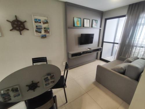 a living room with a table and a couch at Eco Summer Tambau 306 in Tambaú