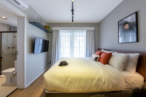 a bedroom with a large bed and a window at House of Charlie Paraiso in Sao Paulo