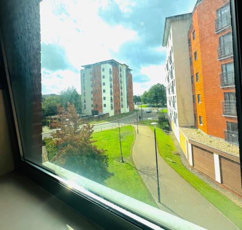 a window with a view of a street and buildings at Spacious Room in Cardiff Bay Apartment with Private Bathroom in Cardiff