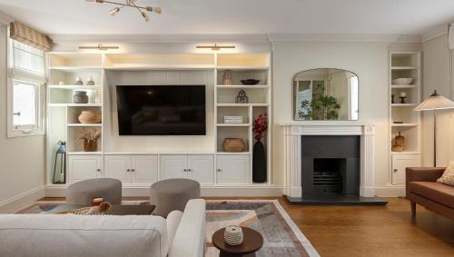a living room with a couch and a fireplace at Charming Family Retreat 4BR Marylebone in London