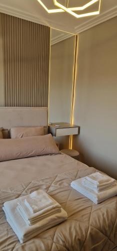 a bedroom with a bed with towels on it at Kaltak Luxury Stay in Bar