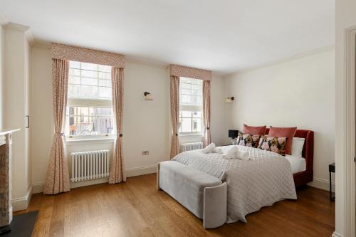 a white bedroom with a bed and two windows at Charming Family Retreat 4BR Marylebone in London