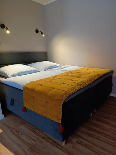 a large bed with a yellow blanket on top of it at Studio-Apartment in Eisenberg, Thüringen in Eisenberg