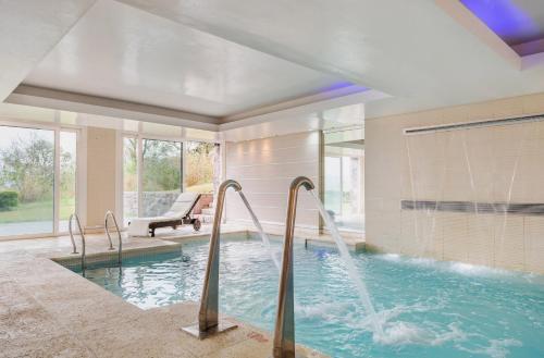 a swimming pool with two water fountains in a house at Altos de la Viña, Wine Hotel & Spa in San Salvador de Jujuy