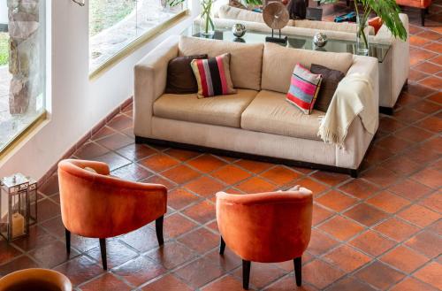 a living room with a couch and two chairs at Altos de la Viña, Wine Hotel & Spa in San Salvador de Jujuy