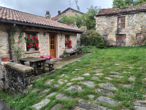 a stone house with a picnic table in the yard at La Casa di Bianca - Intero appartamento in Collagna