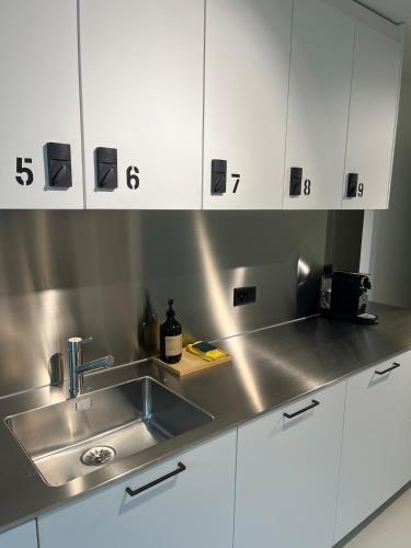 a kitchen with a sink and white cabinets at CoLiving Steinmaur in Dielsdorf