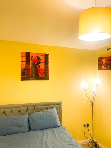 a bedroom with a bed and a yellow wall at Wilsuel homestay in Wolverhampton
