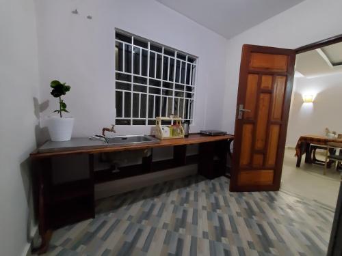 a bathroom with a sink and a wooden desk at Faraja Homestay Mwanza in Mwanza
