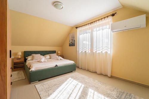 a bedroom with a bed and a large window at Varga Apartman Balatonberény in Balatonberény