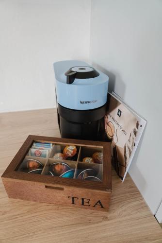 a coffee maker and a box of tea on a table at Ferienwohnung Emilia in Schiefling am See
