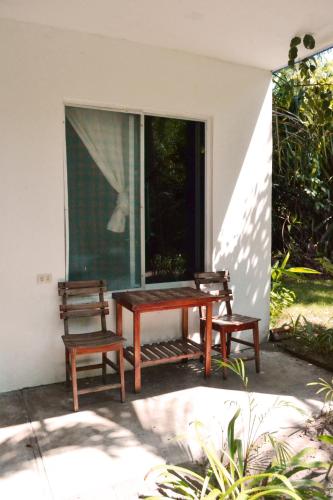 a picnic table and two chairs on a patio at Hotel Cocoloco in Costa Esmeralda