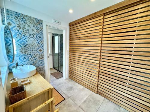 a bathroom with a large wooden wall at Dipinto di Blu in Aci Castello