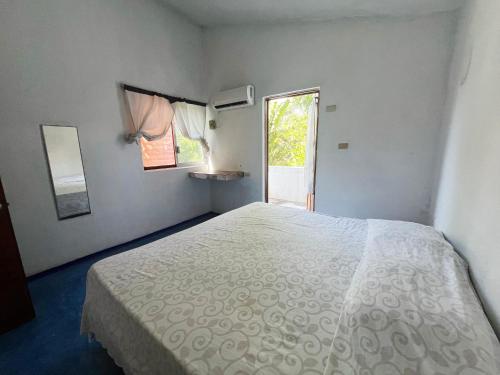 a bedroom with a white bed and a window at Hotel Cocoloco in Costa Esmeralda
