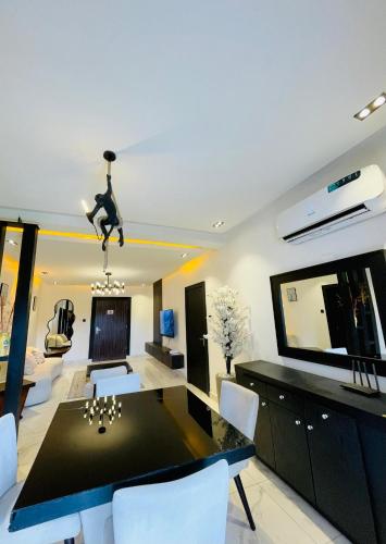 a dining room with a black table and white chairs at Alphavista Luxury Apartments in Port Harcourt
