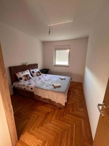 ein Schlafzimmer mit einem Bett und einem Holzboden in der Unterkunft Maša&Marko in Trebinje
