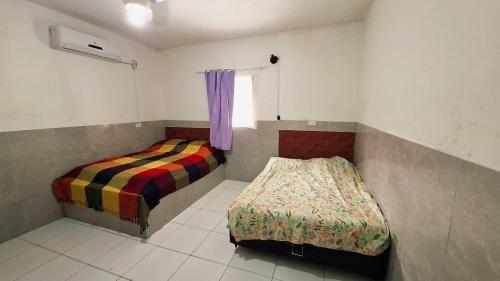 a bedroom with two beds and a window in it at Enseadabechouse in Cabo de Santo Agostinho
