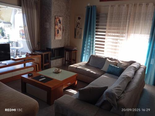 a living room with a couch and a coffee table at Lia Luxury home 2ΥΔ 110 τ μ in Chrysoupolis