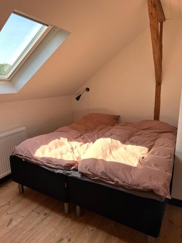 a bed in a room with a window at Charming apartment by forest & beach on Tåsinge in Svendborg