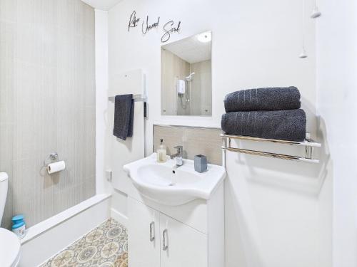 a white bathroom with a sink and a mirror at Bijou Abode- bungalow- free private parking and secure cabin in Great Driffield