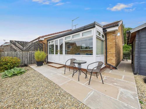a tiny house with a table and chairs on a patio at Bijou Abode- bungalow- free private parking and secure cabin in Great Driffield