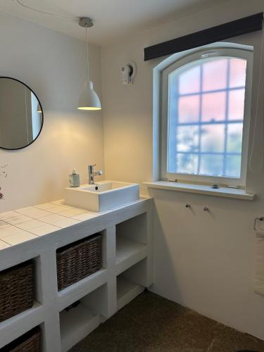 a bathroom with a sink and a window at Charming apartment by forest & beach on Tåsinge in Svendborg