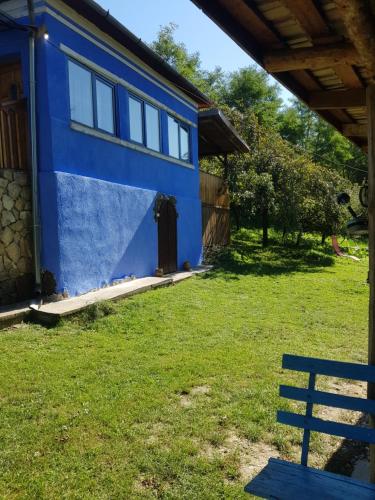a blue house with a bench in the yard at Casa La Casiru 17 in Straja