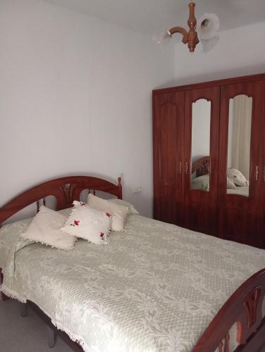 una camera da letto con letto, cuscini e specchio di Casa Rural Labrucena ad Abrucena