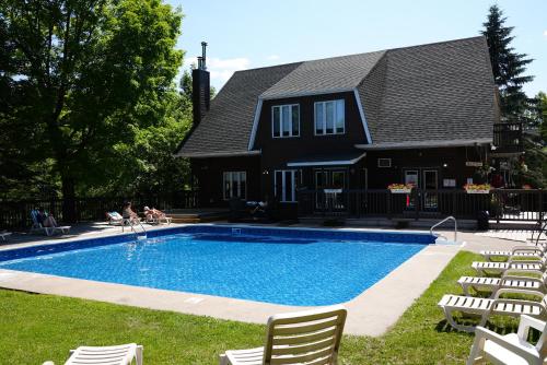 a house with a swimming pool in front of a house at Privilege Mont-Tremblant in Mont-Tremblant