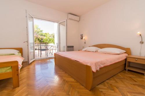 a bedroom with two beds and a balcony at Apartment Family Ribicic in Mandre
