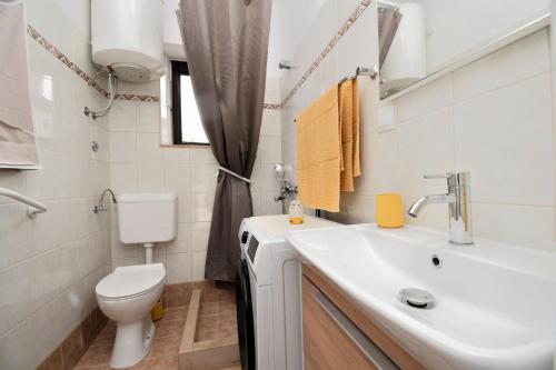 a white bathroom with a toilet and a sink at Apartment Martelina in Manjadvorci