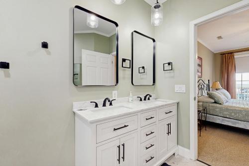 a white bathroom with a sink and two mirrors at Pavilion Watch #1A in Folly Beach