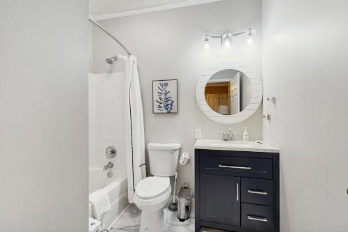 a bathroom with a toilet and a sink and a mirror at Pavilion Watch #1A in Folly Beach