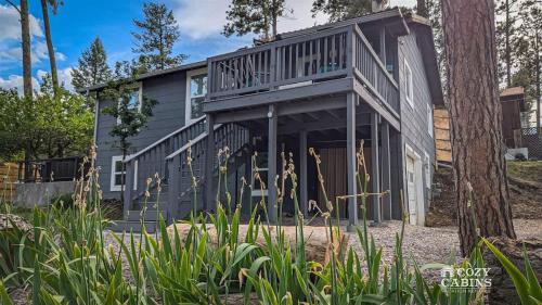 una casa con terraza y un árbol en Yvonnies-Super Cool Convenient Comfy & Renovated Cabin, en Ruidoso