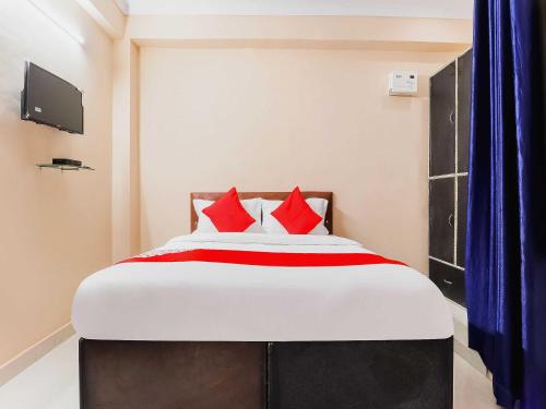 a bedroom with a large bed with red pillows at Hotel O Kalawati Palace in Lucknow