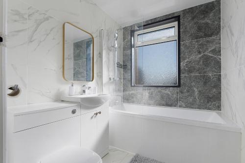a white bathroom with a sink and a mirror at Spenny Homestay - Monthly & Weekly Stays in Byers Green