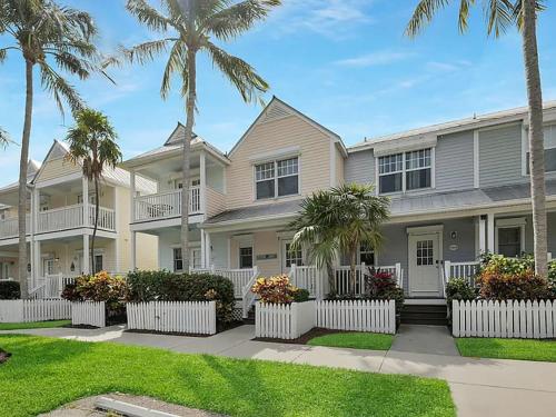 a large house with palm trees in front of it at Villa del Sol - 2-3 Villa - OS Slip Ramp Pkg in Duck Key