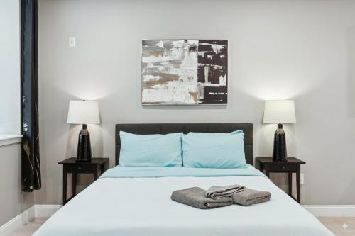 a bedroom with a bed with blue pillows and two lamps at Stay at Luna on Callowhill in Philadelphia