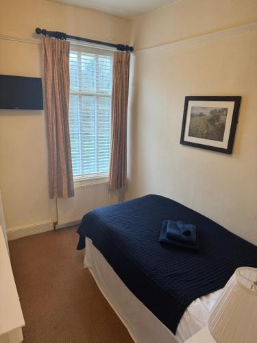 a bedroom with a bed and a window at The Woodland's Hotel in Bradford