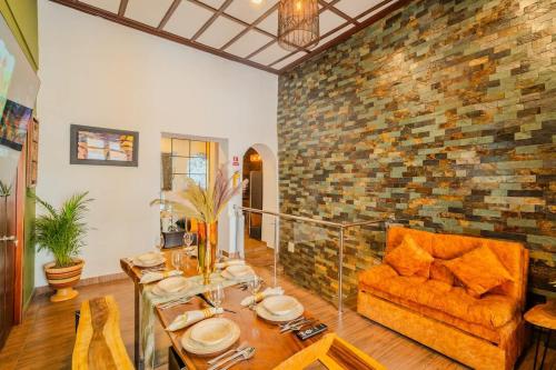 - un salon avec une table et un mur en briques dans l'établissement 7BR Walled City Diamond Villa - Rooftop Heated Jacuzzi, à Carthagène des Indes