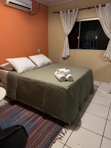 a bedroom with a bed with towels on it at Suítes Sossego in Alto Paraíso de Goiás