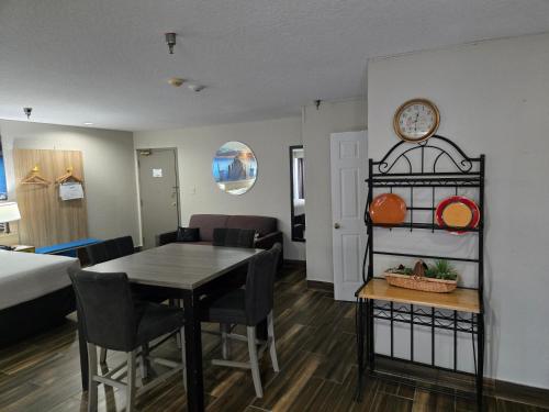 a living room with a dining room table and a bedroom at Days Inn & Suites by Wyndham Tampa/Raymond James Stadium in Tampa