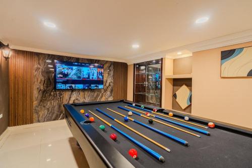 a billiard room with a pool table and a tv at Walled City 9BR Luxury Villa - Jacuzzi & Pool Table in Cartagena de Indias