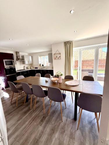 a kitchen and dining room with a table and chairs at Elysian Escape, modern 5 bedroom house in Darlington