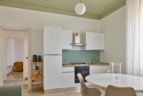 a kitchen with a white table and chairs in a room at Oltre Natura in Canneto Pavese