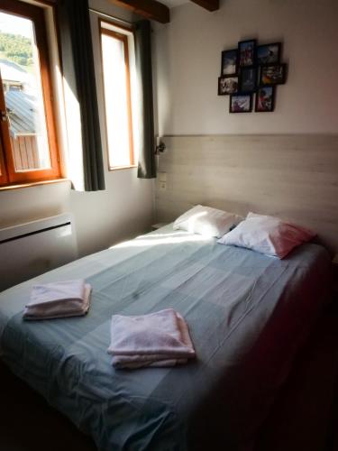 a bedroom with a bed with two towels on it at Hotel Chalet du Crey in Valmorel