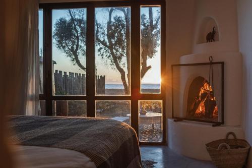 a bedroom with a fireplace in front of a window at La Mouette et les Dromadaires in Essaouira