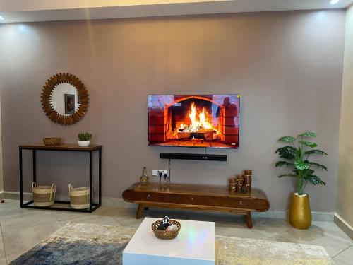 a living room with a fireplace on the wall at Oasis Villas- Naalya in Kampala