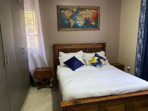 a bed with blue and white pillows in a bedroom at Oasis Villas- Naalya in Kampala